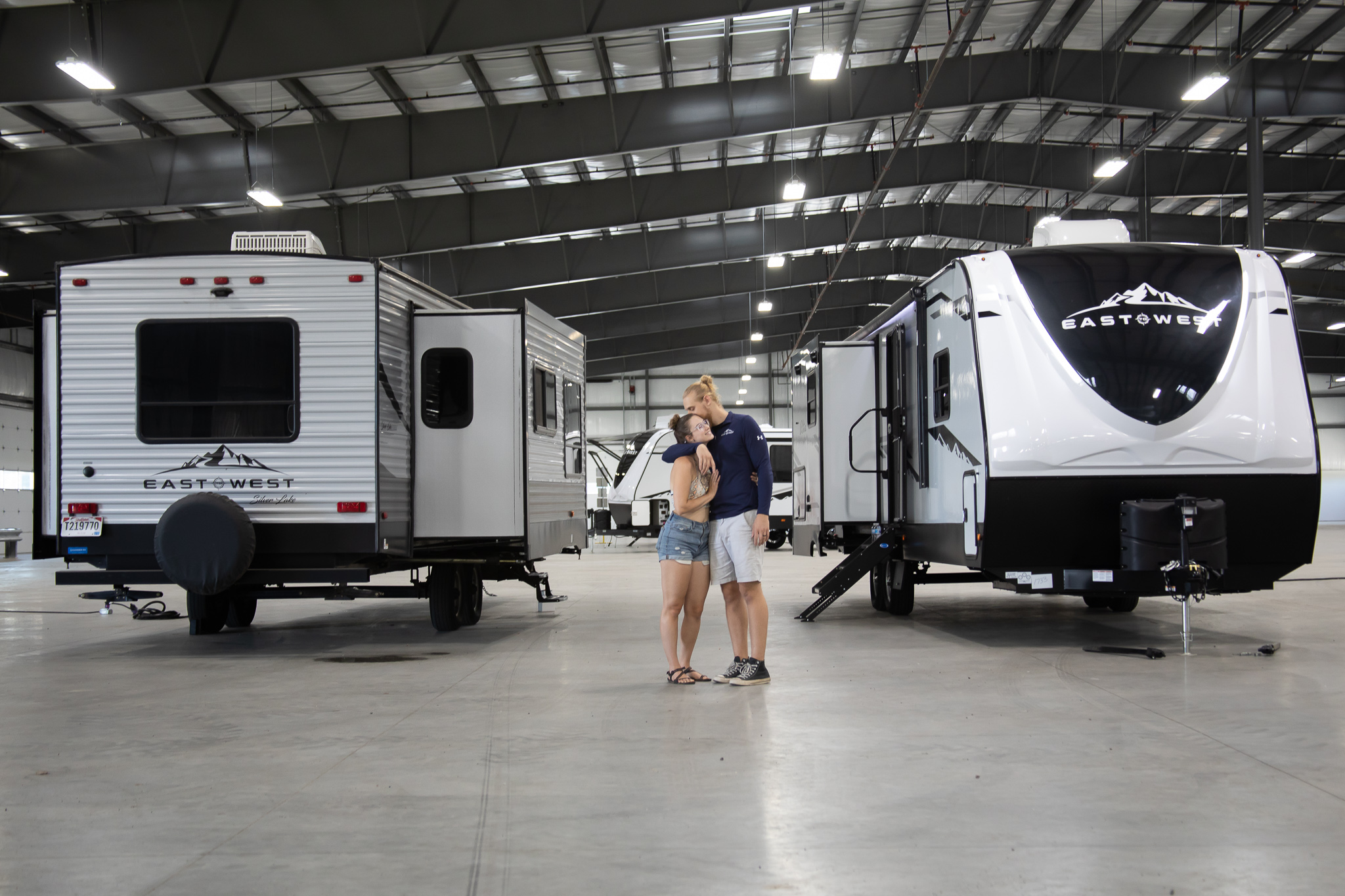 two people standing next to RVs