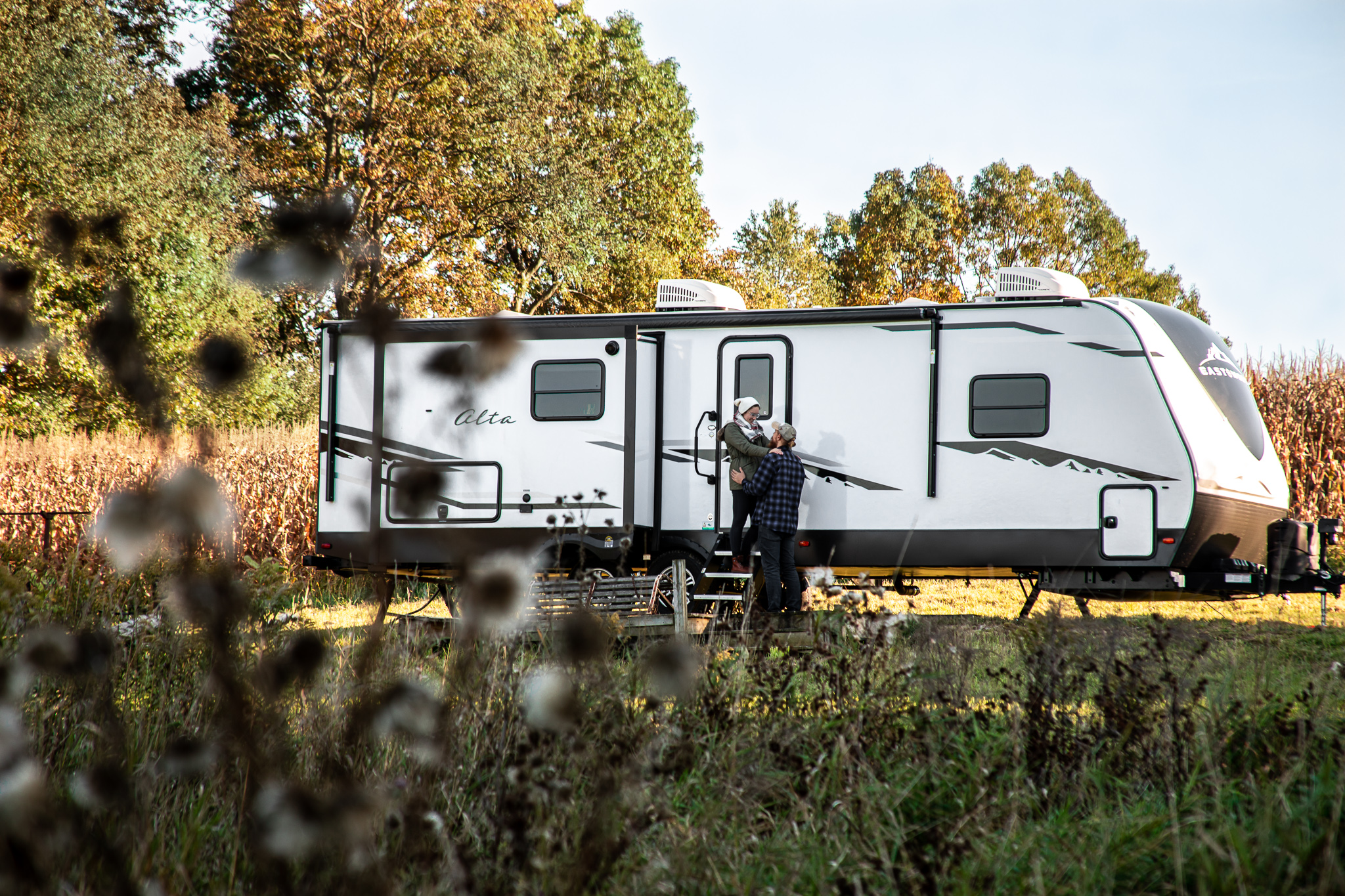 White camper with two people standing next to it
